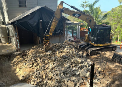 Excavator removing demolition debris from construction site